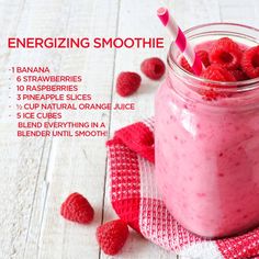 a jar filled with raspberry smoothie next to strawberries