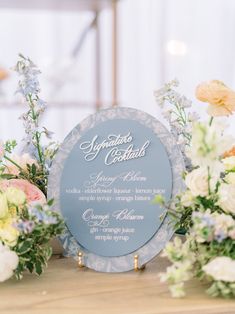 a table topped with flowers and a blue plaque that says signature guests on it's side