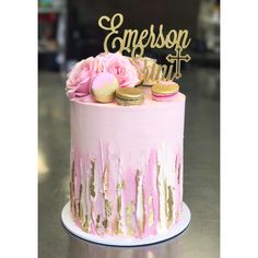 a cake with pink frosting and gold sprinkles is on a table