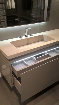 a bathroom sink sitting under a mirror next to a counter top with drawers underneath it