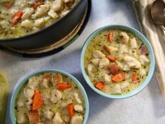 three bowls of chicken and dumpling soup on a table