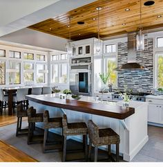 a large kitchen with an island in the middle and lots of counter space on one side