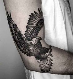 a black and white eagle tattoo on the arm