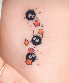 a woman's stomach with two small black and orange spiky creatures on it