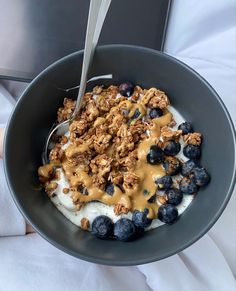 a bowl filled with yogurt, granola and blueberries