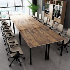 a large wooden table surrounded by chairs in an office setting with windows overlooking the city