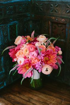 a vase filled with pink and orange flowers