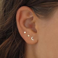 a woman's ear with two stars and a moon on it