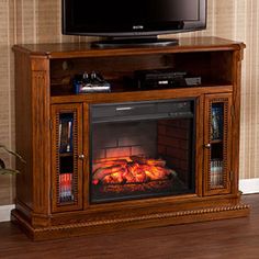 an entertainment center with a fireplace in the corner and a flat screen tv on top