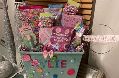 a blue basket filled with lots of different types of crafts and buttons on top of a table