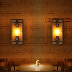 two lights are on the brick wall above a table with chairs and a candle in front of it