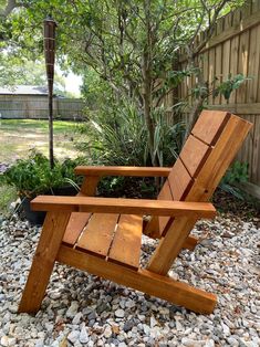 a wooden lawn chair sitting on top of gravel