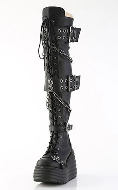 Get ready to dominate the room with the MORTE-215s! These thigh highs boots feature grommet buckle straps and metal skull knockers, be the badass that you are. 4 1/2" (114mm) Wedge Platform Lace-Up Front Thigh-High Boot Featuring 2 Double Grommet Buckle Straps with Metal Skull Knockers at Center and 2 Lower Skull Buckle Straps Skull Knockers on the Outer Heel & Toe Hanging Chain Detail Blacklight Reflective Back Coffin Inside Metal Zip Closure US women's sizing-refer to size chart for more info. Leather Thigh High Boots, Metal Skull, Black Vegan, Knee High Leather Boots, Thigh High Boots, Platform Wedges, Thigh High, Thigh Highs, Knee High Boots