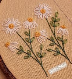 some flowers are embroidered onto a piece of fabric