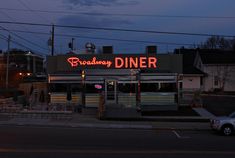 a restaurant with neon sign on the side of it