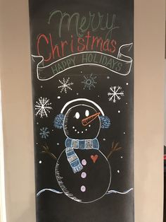 a chalk board with a drawing of a snowman and merry christmas written on it