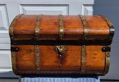 an old wooden trunk sitting on top of a blue towel in front of a white door