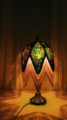 a lamp that is sitting on top of a table next to a curtained wall