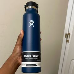 a hand holding a hydro flask in front of a door