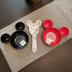 mickey mouse plates and spoons are sitting on a place mat next to each other