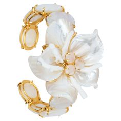 The Cassie Cuff, crafted from semi-precious stones, showcases a unique and sizable flower at its center, embodying the distinctiveness of our brand. Its vintage-style design adds to its allure. SKU: CF-FL-31 Stones: White Coral, Mother of Pearl & Moonstone Material: 14K Gold Plated Dimensions: 2" Luxury Flower Jewelry For Evening, Luxury Flower-shaped Jewelry For Evening, Luxury Flower-shaped Evening Jewelry, Elegant Gemstone Cuff Bracelet For Wedding, Luxury Gemstone Cuff Bracelet For Weddings, Elegant White Gemstone Cuff Bracelet, Elegant Flower Shaped Cuff Bracelet, Elegant Flower Cuff Bracelet, Elegant Flower-shaped Cuff Bracelet