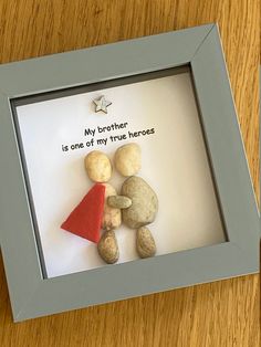 a shadow frame with rocks and a paper cut out of it that says, my brother is one of my true heros