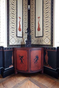 an ornately painted cabinet in the corner of a room