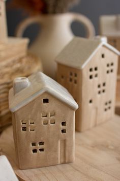 two clay houses sitting on top of a wooden table