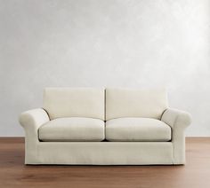 a white couch sitting on top of a wooden floor