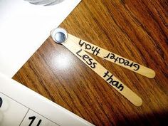 two wooden spoons sitting on top of a table next to a measuring tape with words written on them