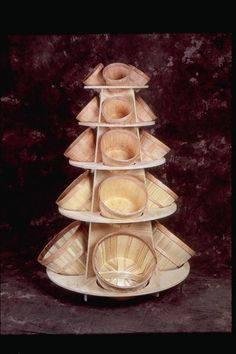 a stack of wooden bowls sitting on top of each other in front of a wall