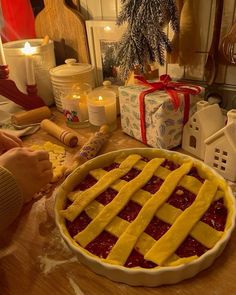 a pie sitting on top of a wooden table next to candles and other holiday decorations