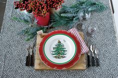 a place setting with christmas tree plates and silverware