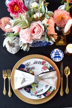 a table set with plates, silverware and flowers