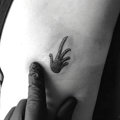 a black and white photo of a person's foot with a lizard tattoo on it