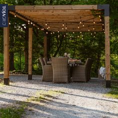 an outdoor dining table and chairs under a wooden pergolan with lights on it