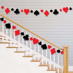 red and black playing cards are hanging on the banisters in front of a staircase