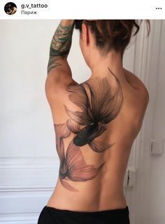 the back of a woman's body with tattoos on it