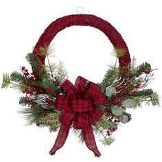 a red and black wreath with pine branches, berries and greenery tied around it