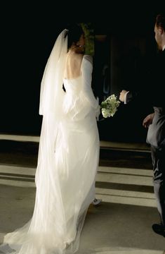 a bride and groom walking down the street