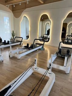 an empty gym with mirrors and treadmills on the floor in front of them