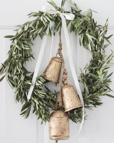 two bells hanging from a wreath on a door