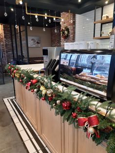 the counter is decorated for christmas with garland on it and lights hanging from the ceiling