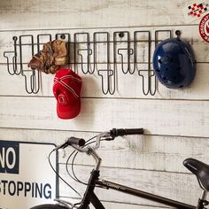 a bicycle is parked in front of a sign that says no stopping and there are helmets hanging on the wall