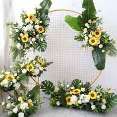 two wreaths with sunflowers and other flowers are arranged in front of a mirror