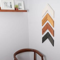 a chair sitting in front of a wall with pictures hanging on it's side