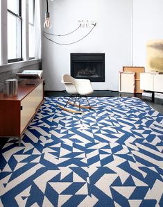 a living room with a blue and white rug on the floor next to a fireplace