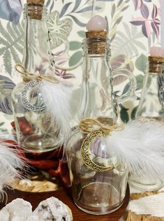 three glass bottles with feathers in them sitting on a table next to some cookies and other items