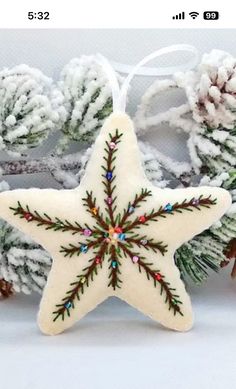 a white star ornament hanging from a christmas tree