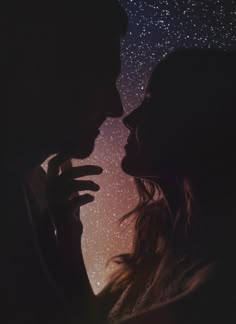 two people standing next to each other in front of a night sky with stars above them